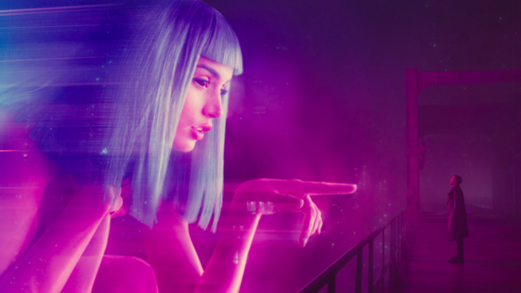 Image extraite du film Blade Runner 2049. On y voit une femme géante en hologramme  face au personnage de K, joué par Ryan Gosling.